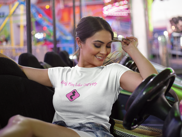 Beautiful curvy woman sitting in bumper car wearing t-shirt that says Real Men Like Curves