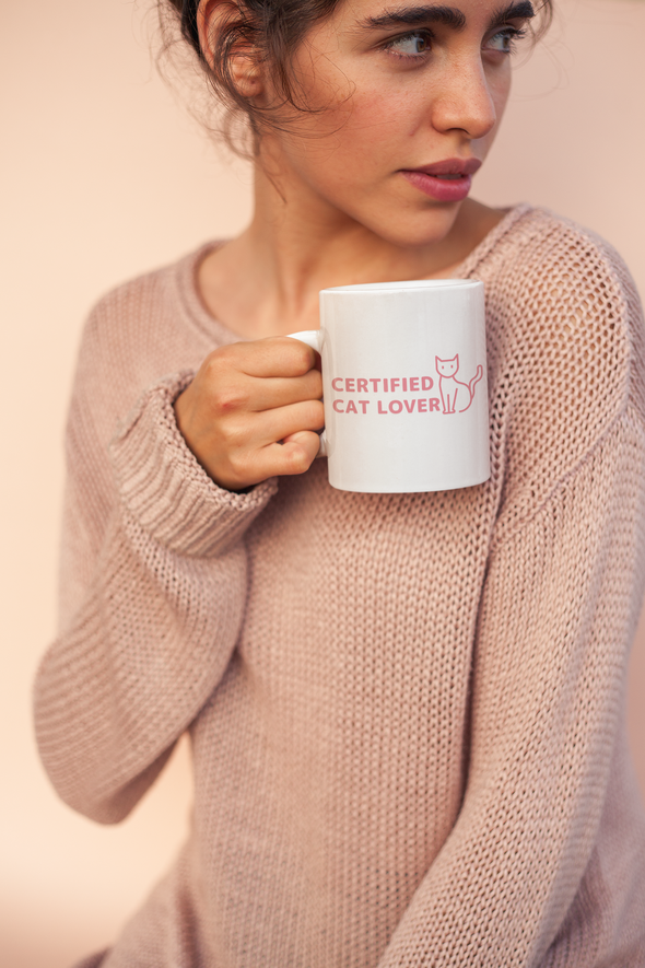 coffee mug that says certified cat lover -held-by-a-woman-wearing-a-cozy-sweater-