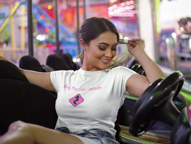 Beautiful curvy woman sitting in bumper car wearing t-shirt that says Real Men Like Curves