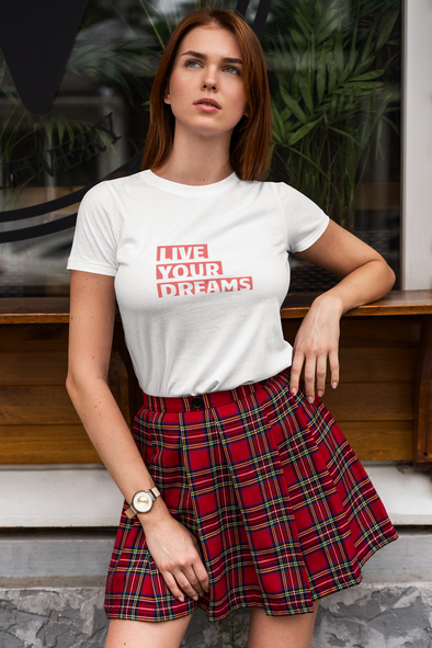 attractive young woman wearing a plaid skirt, and t-shirt that says LIVE YOUR DREAMS
