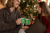 a couple drinking hot cocoa from Coffee Mugs with Santa on green background that says Don't Stop Believing  