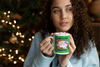 woman drinking hot cocoa from a mug that says DON'T STOP BELIEVING (in Santa)