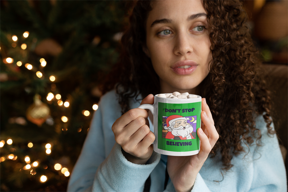 woman drinking hot cocoa from a mug that says DON'T STOP BELIEVING (in Santa)