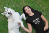 woman lying on the grass with her dog wearing black t-shirt that says HOME IS WHERE MY DOG IS